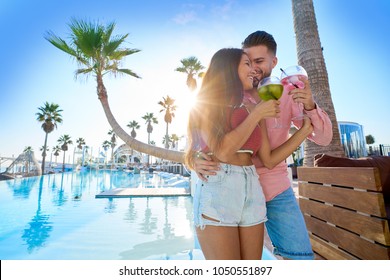 Young Couple Drinking Cocktail In A Resort Pool In Summer Vacation