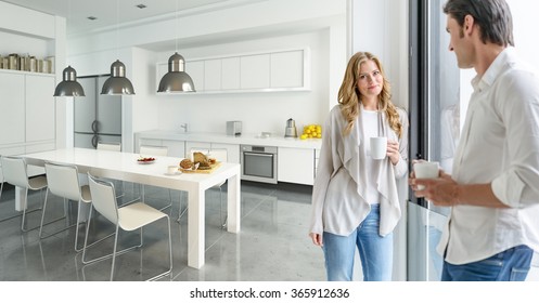 Young couple drinking coffee in a modern kitchen - Powered by Shutterstock