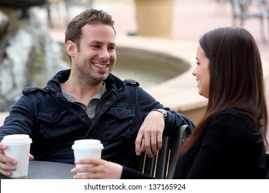 Young couple drinking coffee outside