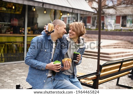 young couple drinking coffee while walking around the city