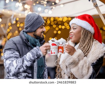 Young couple drinking hot chocolate at christmas market - Powered by Shutterstock