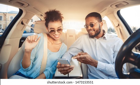 Young Couple Driving Car And Using Digital Map On Smartphone, Panorama