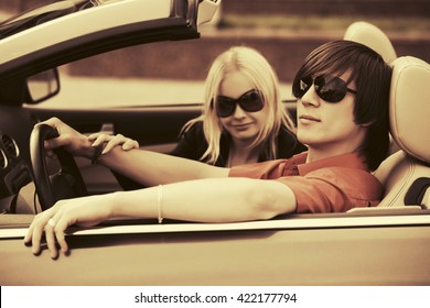 Young Couple Driving Convertible Car