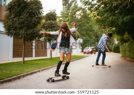 Similar – Happy young woman riding on skate with her friends