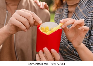 Young Couple Eating French Fries, Closeup