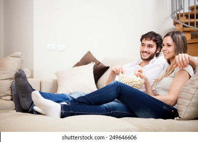 Young Couple Eating Popcorn While Watching A Movie