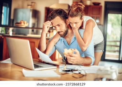 Young couple embracing each other during a financial crisis in the kitchen of their home