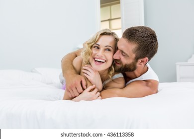 Young couple embracing on bed at bedroom