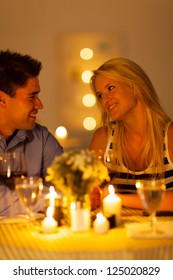 Young Couple Enjoying Candlelight Dinner In A Restaurant