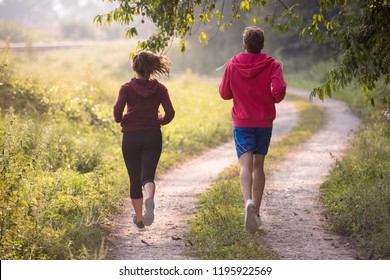 young couple enjoying in a healthy lifestyle while jogging along a country road, exercise and fitness concept - Shutterstock ID 1195922569