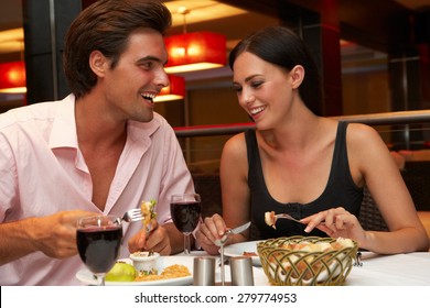 Young Couple Enjoying Meal In Restaurant
