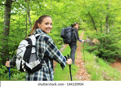 Young Couple Enjoying Nordic Walking In A Forest