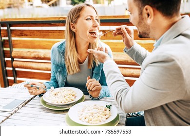 Young Couple Enjoying Restaurant And Eating Pasta.