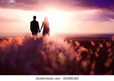 Young couple enjoying the sunset in the meadow