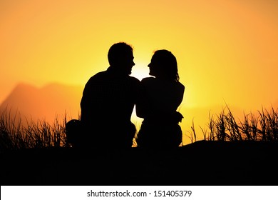 Young couple enjoying the sunset on the beach. 