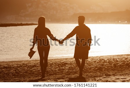 Young couple enjoying vacation on tropical beach - Romantic lovers silhouette having fun together on summer holidays - Travel people love and relationship concept 