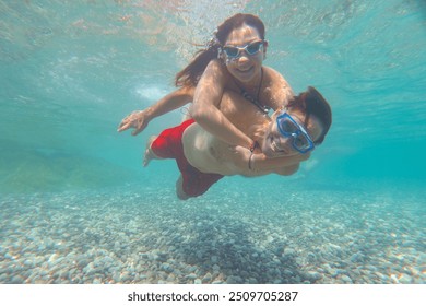 young couple enjoys diving underwater in a tropical sea together - Powered by Shutterstock