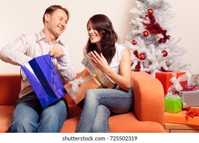 Young Couple Exchanging Christmas Gifts - Shutterstock ID 725502319