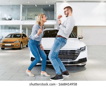 Young couple excited about buying a new car. Jumping and celebrating in front of the vehicle - Powered by Shutterstock