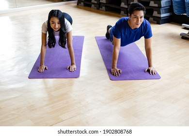 Young couple with exercise by doing yoga on yoga mat in exercise room at gym. Exercise with yoga.