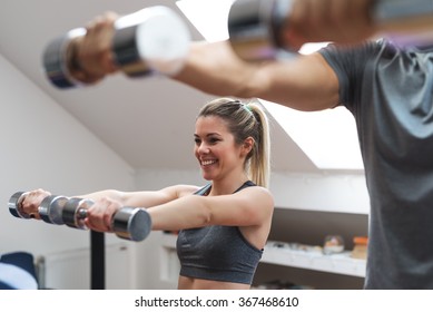 Young Couple Exercising With Dumbbells At Home. 