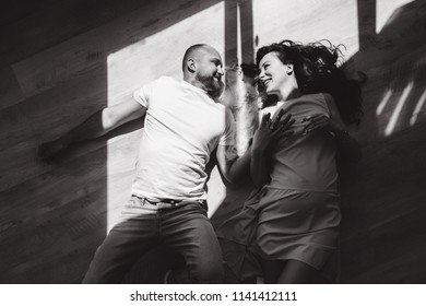 Young Couple Expecting Baby Laying On The Beam Of Light With A Dog Indoors