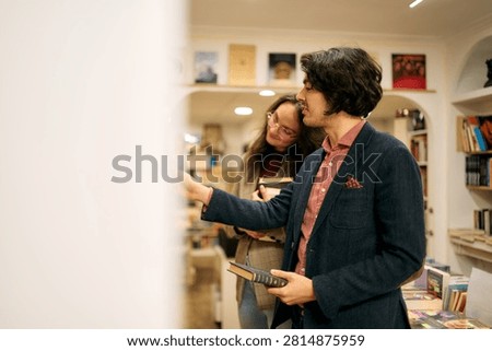Young couple exploring a bookstore, selecting books and enjoying a shared interest in literature and learning