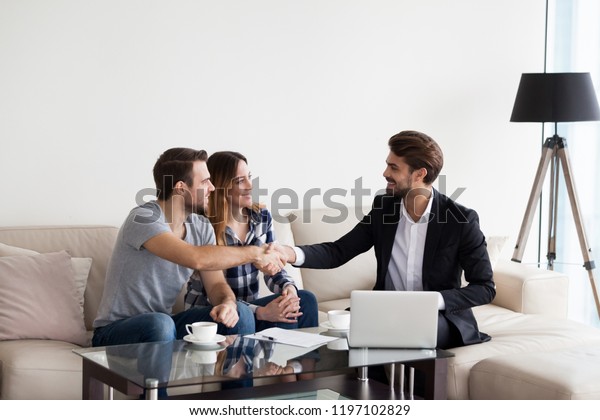 Young\
couple, family at meeting with realtor, interior designer,\
decorator, landlord making deal. Husband handshaking with man in\
suit. Concept of meeting with client,\
customer