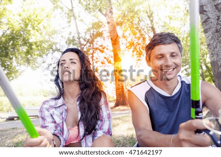 young couple fishing on the banks of the pond