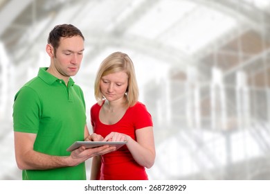 young couple in front using tablet pc together