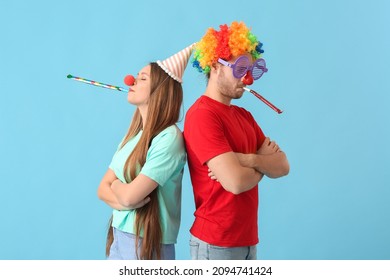 Young Couple In Funny Disguise On Color Background. April Fools Day Celebration