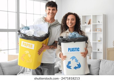 Young couple with garbage containers at home. Recycling concept - Powered by Shutterstock