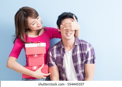 young couple with gift isolated on blue background - Powered by Shutterstock