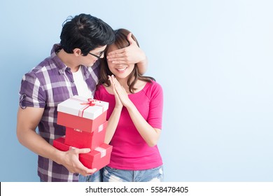 young couple with gift isolated on blue background - Powered by Shutterstock