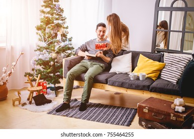 Young couple with gifts in front of Christmas tree - Shutterstock ID 755464255