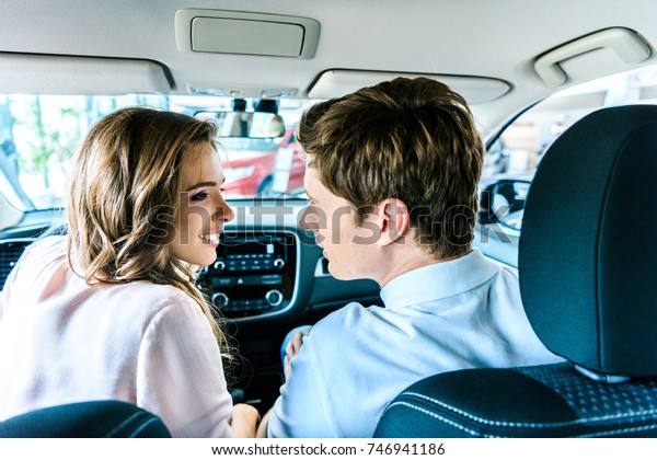 Young couple\
going to kiss while sitting in\
car