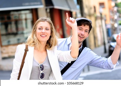 Young Couple Hailing For A Taxi Cab