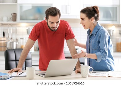 Young Couple Having Argument About Family Budget In Kitchen