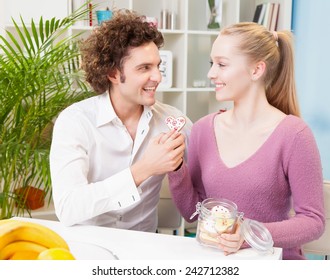 Young couple having breakfast at home.