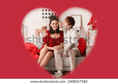 Young couple having date at home, visible through red heart. Valentine's day celebration