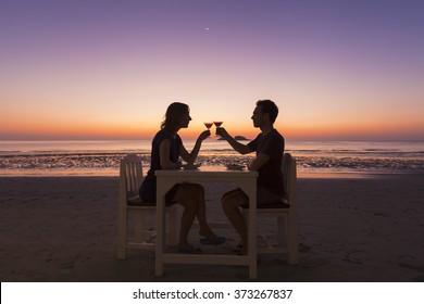 Young Couple Having A Diner At A Beach Restaurant, Tropical Resort, Sunset