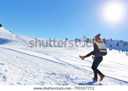 Young couple having fun on snow. Happy man at the mountain giving piggyback ride to his smiling girlfriend.