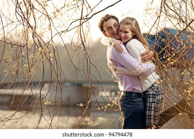 Young Couple Having Fun At River Beach In Early Spring