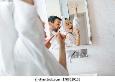 Young couple having fun and singing in bathroom - Powered by Shutterstock