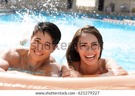 young Couple having fun in swimming pool
