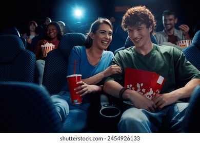 Young couple having fun while watching movie in cinema.