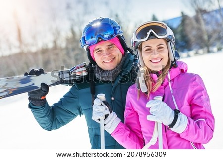 Young couple having fun while winter skiing