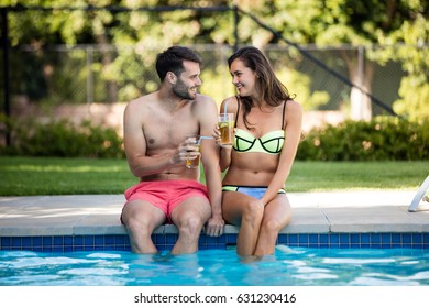 Young couple having iced tea at poolside on a sunny day - Powered by Shutterstock