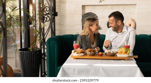 Young couple having a lunch and drinking fresh squeezed juice in the restaurant - Powered by Shutterstock