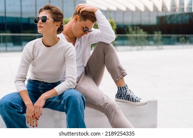 Young Couple Having Problems In Their Relationship. Man And Woman Friends In Sunglasses Sitting Bench In City Unhappy Emotions. Relationships Problem.